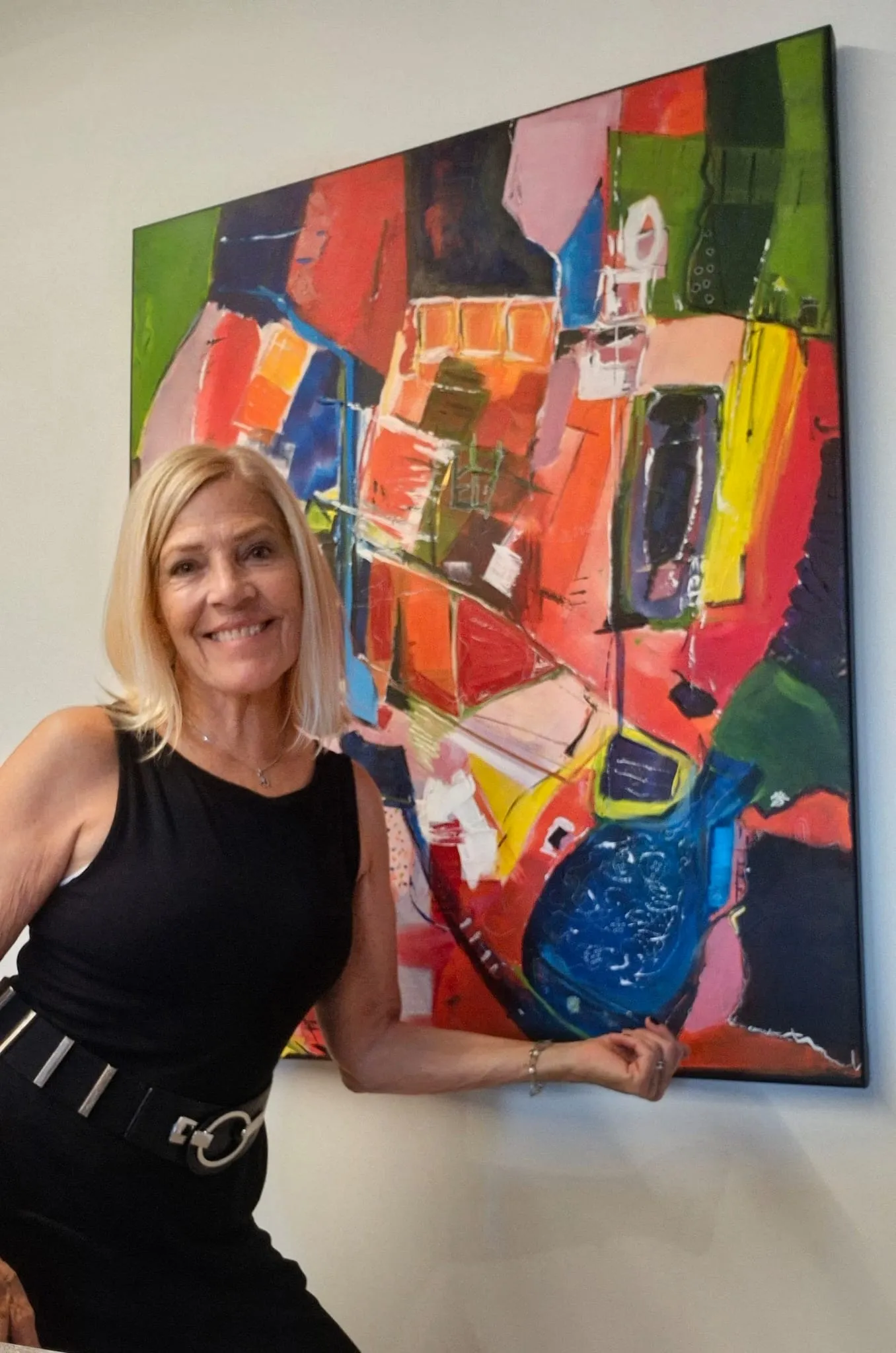 Paula Harmsen, abstract painter, beside one of her colourful paintings